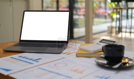 Foto de Laptop computer, calculator, financial document and coffee cup on white office desk. - Imagen libre de derechos