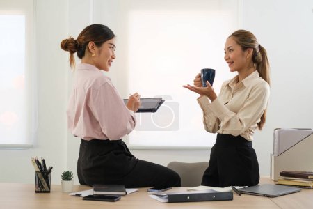 Téléchargez les photos : Indien attrayant femme positive parler avec un collègue pendant la pause café au coworking sont - en image libre de droit