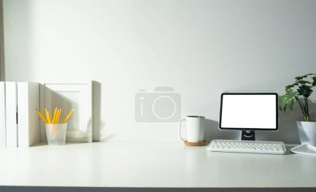 Téléchargez les photos : Tablette numérique, livres, cadre photo et tasse à café sur table blanche. - en image libre de droit
