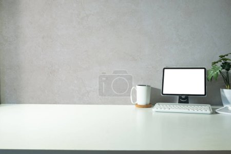 Téléchargez les photos : Minimal workplace with digital tablet, cup of coffee and houseplant on white table. Copy space for text. - en image libre de droit