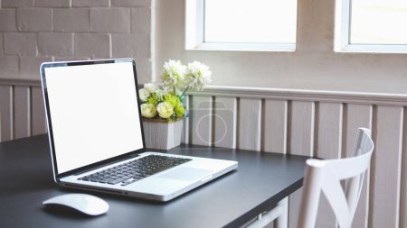 Photo for Comfortable workplace with laptop computer and potted plant on black wooden table. Blank screen for your advertise design. - Royalty Free Image