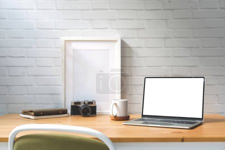 Photo for Laptop computer with white empty screen, picture frame, camera and coffee cup on white table. - Royalty Free Image