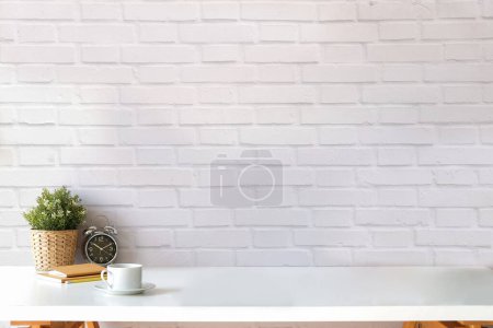 Photo for Minimal cozy home interior with potted plant, alarm clock, books and coffee cup on desk. For display or montage your products. - Royalty Free Image