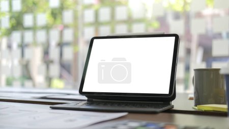 Foto de Tableta digital con pantalla en blanco, documento y taza de café en el escritorio de la oficina blanca. - Imagen libre de derechos