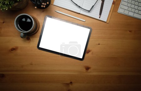 Téléchargez les photos : Tablette numérique avec écran vide, tasse à café, ordinateur portable et clavier sur table en bois. - en image libre de droit