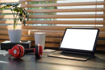 Téléchargez les photos : Lieu de travail élégant avec tablette numérique, casque, tasse à café et plante d'intérieur sur table en bois noir. - en image libre de droit