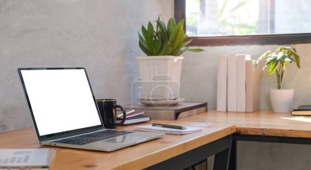 Foto de Laptop computer with blank screen, coffee cup on table Comfortable workplace. - Imagen libre de derechos