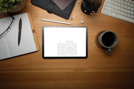 Photo for Wooden working desk with digital tablet, coffee cup, eyeglasses and notebook. Top view with copy space. - Royalty Free Image
