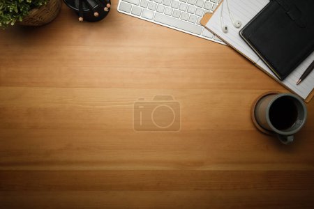 Téléchargez les photos : Vue de dessus du lieu de travail simple avec tasse de café, crayons et bloc-notes sur table en bois. Vue du dessus - en image libre de droit