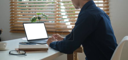 Téléchargez les photos : Homme d'affaires adulte assis dans un bureau lumineux et utilisant un ordinateur portable. - en image libre de droit