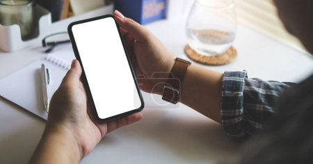 Photo for Cropped shot view of man using smart phone at office desk. Blank  screen for your text message or information content. - Royalty Free Image
