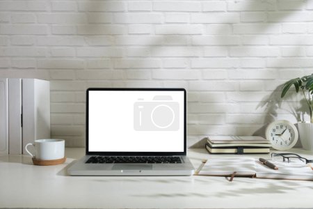Photo for Laptop computer with empty display, picture frame and stationery on wooden working desk. - Royalty Free Image