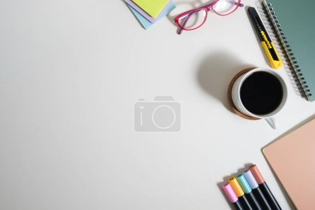 Foto de Vista superior de la taza de café, vasos, libros y papelería sobre fondo blanco. Copia espacio para tu texto. - Imagen libre de derechos