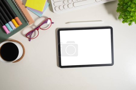 Téléchargez les photos : Pose plate, vue du dessus de la tablette numérique avec écran vide, lunettes et papeterie sur table blanche. - en image libre de droit