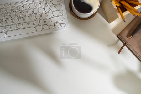 Téléchargez les photos : Vue du dessus du clavier, de la tasse à café et de la papeterie sur le bureau blanc. - en image libre de droit
