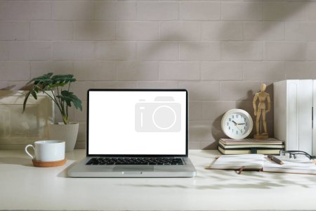 Foto de Ordenador portátil con pantalla en blanco, planta de interior, taza de café y portátil en la mesa blanca. - Imagen libre de derechos