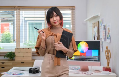Photo for Portrait of young asian female graphic designer in stylish clothes holding graphic tablet standing at creative office. - Royalty Free Image