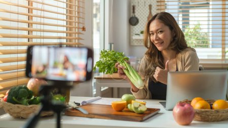 Téléchargez les photos : Une nutritionniste professionnelle parle d'une alimentation saine et enregistre un blog vidéo sur un téléphone intelligent. - en image libre de droit