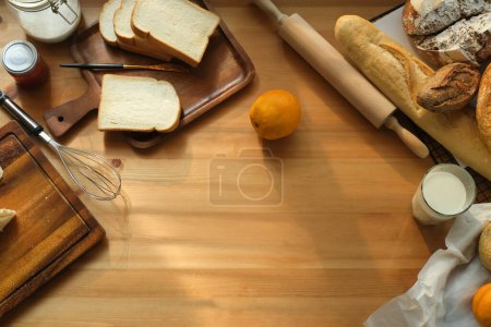 Foto de Vista superior de pan recién horneado y utensilios de cocina en mesa de madera con espacio para copiar. - Imagen libre de derechos