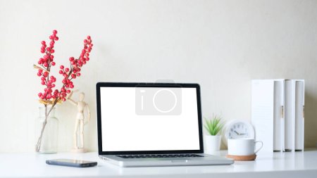 Photo for White working desk with laptop, coffee cup and books. Modern workspace, blank screen for your advertise text. - Royalty Free Image