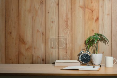 Photo for Home office desk with books, cup of coffee, pencil holder and houseplant. Copy space for your text. - Royalty Free Image