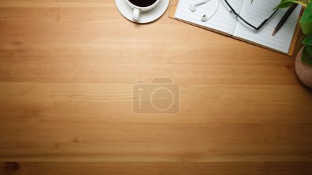 Foto de Lugar de trabajo sencillo con taza de café, vasos, cuaderno y maceta de la planta en la mesa de madera. Vista superior con espacio de copia. - Imagen libre de derechos
