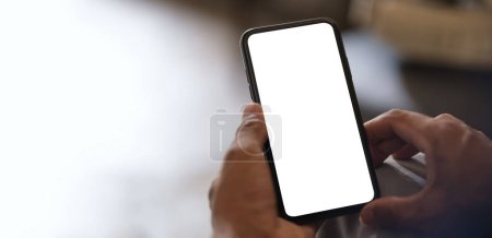Foto de Vista de primer plano de las manos sosteniendo el teléfono inteligente con pantalla en blanco y el lado izquierdo con espacio vacío para su anuncio o mensaje de texto. - Imagen libre de derechos