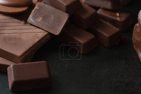 Photo for Pieces dark chocolate on black background. Closeup view shot. - Royalty Free Image