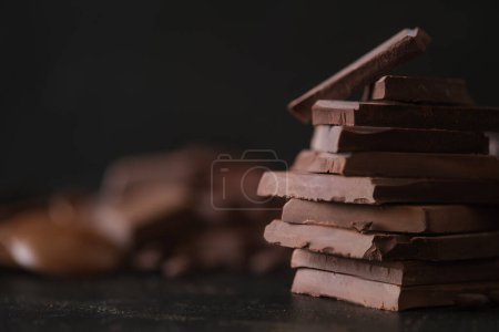 Photo for Stack of dark chocolate pieces empty space for text. Dessert food background. - Royalty Free Image