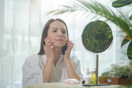 Foto de Beautiful caucasian woman with sheet mask on her face, doing beauty treatment at home. Beauty routine, self care concept. - Imagen libre de derechos