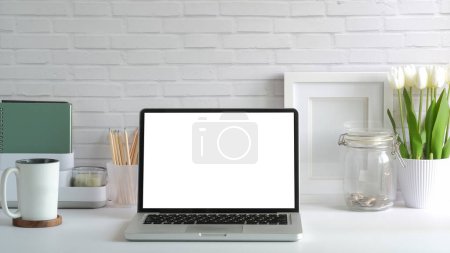 Téléchargez les photos : Front view of laptop computer, coffee cup and potted plant on white table. Empty screen for your advertise design. - en image libre de droit
