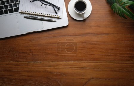 Foto de Flat lay laptop, cup of coffee and notebook on wooden table. Top view with copy space. - Imagen libre de derechos