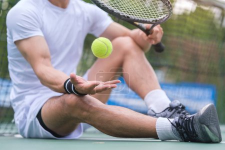 Téléchargez les photos : Homme en vêtements de sport blanc tenant raquette et balle reposant court de tennis. Sport, compétition, mode de vie sain et actif concept. - en image libre de droit