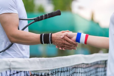 Photo for Cropped shot of two tennis players players shaking hands over the net after the match. - Royalty Free Image