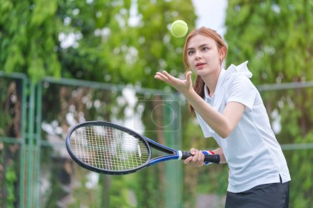 Téléchargez les photos : Jeune joueur de tennis vomissant une balle, se préparant à servir lors d'un match. - en image libre de droit