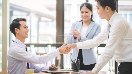 Photo for Business people shaking hands greeting getting acquainted in office, investment deal or finishing up meeting. - Royalty Free Image