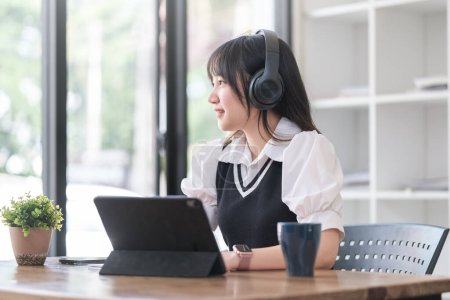 Téléchargez les photos : Réfléchie jeune asiatique femme écoute de la musique sur sans fil casque et regarder par la fenêtre. - en image libre de droit