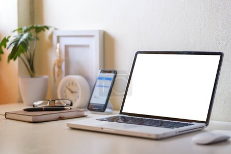 Photo for Laptop computer and smartphone with blank screens on white table. - Royalty Free Image