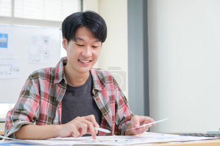 Téléchargez les photos : Jeune homme asiatique UX concepteur planification développement d'applications, croquis mise en page de modèle au bureau. - en image libre de droit