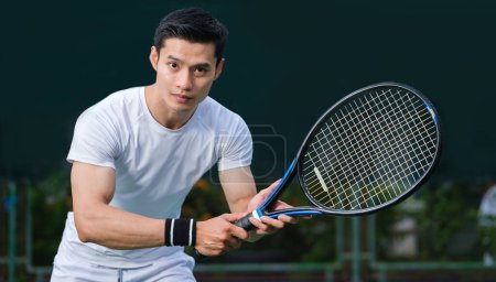 Téléchargez les photos : Sportif motivé en costume blanc jouant au tennis sur un terrain extérieur. Sport, compétition, mode de vie sain et actif concept. - en image libre de droit