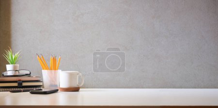 Photo for Comfortable workplace with coffee, stationery and houseplant on white table. Home office, copy space. - Royalty Free Image
