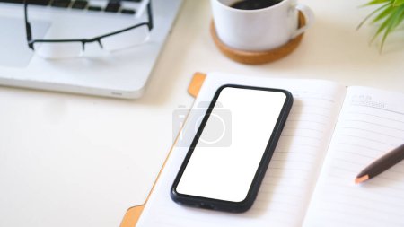 Photo for Office desk with smart phone, laptop computer, notebook and coffee cup. Copy space. - Royalty Free Image