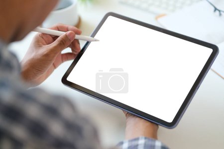 Téléchargez les photos : Vue sur les mains épaule homme d'affaires en utilisant une tablette numérique au bureau de travail blanc. - en image libre de droit