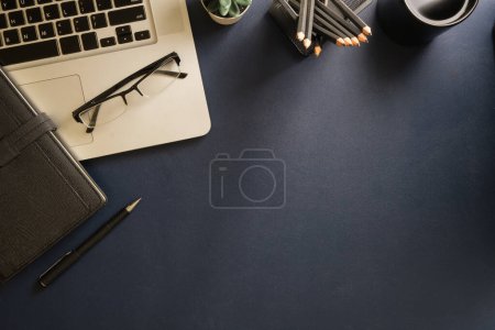 Photo for Top view simple workplace with laptop computer, coffee cup, and potted plant on background. - Royalty Free Image