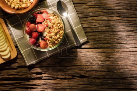 Photo for Yogurt bowl with granola and berries on wooden table. Healthy food, vegan, dieting and weight loss concept. - Royalty Free Image