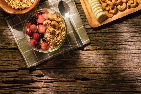 Foto de Yogur con granola y bayas para un desayuno saludable en la mesa de madera. Vista superior con espacio. - Imagen libre de derechos