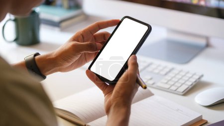Foto de Manos de hombre sosteniendo el teléfono inteligente con pantalla en blanco para su mensaje de texto o contenido de información. - Imagen libre de derechos