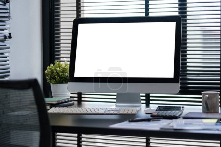 Foto de Vista frontal de una computadora con pantalla en blanco y equipo en el espacio de trabajo del diseñador o fotógrafo. Monitor de pantalla en blanco para montaje gráfico. - Imagen libre de derechos