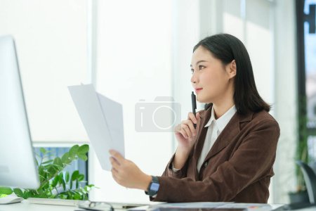 Foto de Portrait of beautiful female executive looking at computer screen, working in modern office. - Imagen libre de derechos