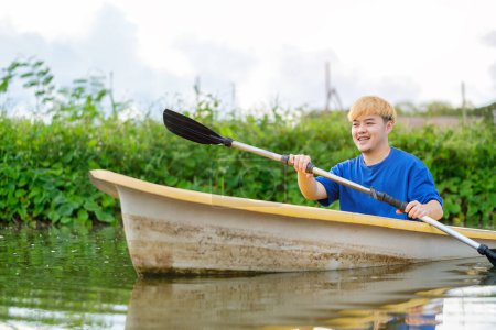 Téléchargez les photos : Homme joyeux touristes rameur bateau avec avirons dans la rivière. Voyages, vacances et activités de plein air. - en image libre de droit